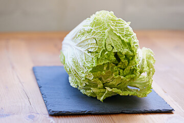 Green vegetable, fresh and cutting board in kitchen for diet, cooking and wellness. Cabbage, whole...