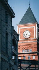 Vertical view of a medieval tower with a clock under the sunlight