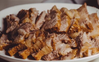 Closeup shot of delicious grilled pork in slices on a white plate, concept of food