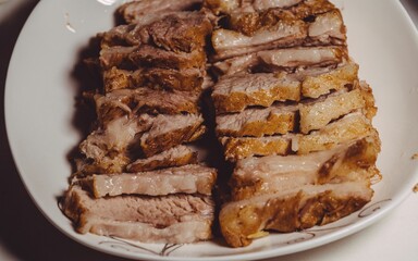Closeup shot of grilled pork in slices on a white plate, concept of food