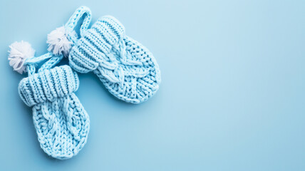 Blue knitted baby shoes on blue background - Powered by Adobe