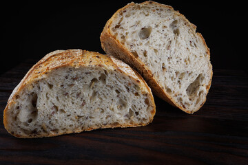 A loaf of bread cut in half on a wooden board. Art bread.