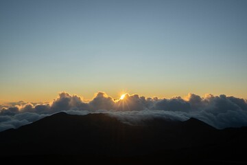 Beautiful shot of a large layer of clouds in a sunset sky visible from a mountain peak