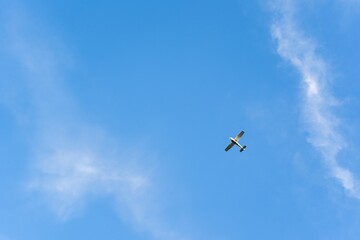 Low angle shot of a plane flying under a blue sky