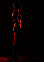 AI Generated Image. Silhouette of the ethnic muscular athlete under the red light - 780450522