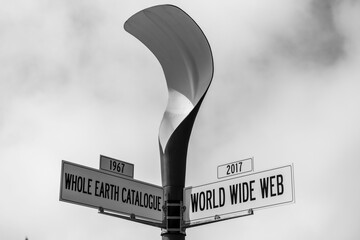 Grayscale of street signs of whole earth catalogue in 1967 and world wide web in 2017