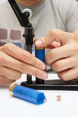 A man make repairing of plastic case for making a cartridges for shooting