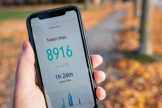Hand of unrecognizable person showing steps count through smart phone app