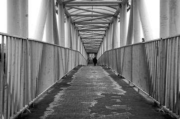 Grayscale shot of a pedestrian bridge.