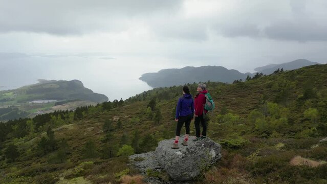 Drone video of mother and daughter at viewpoint near Stolanuten hill top in Nedstrand, Norway