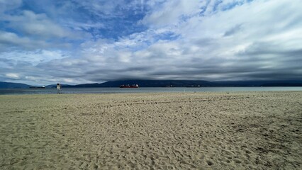 Peaceful sandy beach under endless cloudy sky