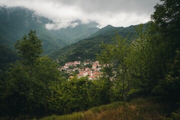 Beautiful shot of a town surrounded by wild forest mountains