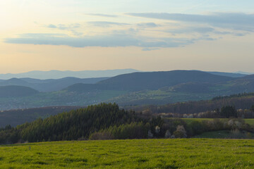 view from the meadow to distant hills and forests