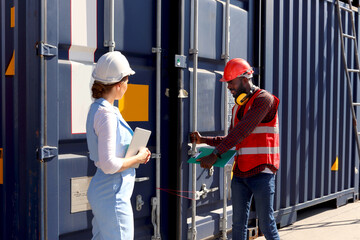Two workers with safety helmet at logistic shipping cargo containers yard. Young beautiful woman...