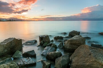 Beautiful long exposure shot of a rocky beach at sunset