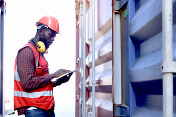 African American young engineer worker man wearing safety bright red vest and helmet, checking data...