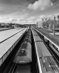 Vertical grayscale shot of the trains moving through the city
