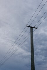 Transmission tower and cloudy sky, vertical