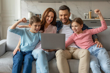 Family celebrating success with laptop at home