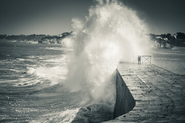 huge wave splash against the dike, in black and white, socoa, basque country