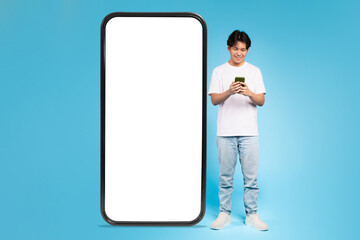 Young guy with phone beside blank screen