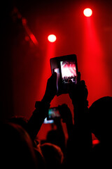 Making photo with smartphone during a concert to share the moment with friends on social networks.