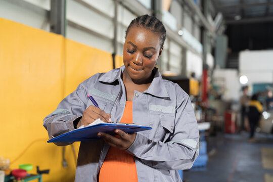 Female mechanic working at garage. Female mechanics checking car engine underneath lifted car at auto car repair service. Car service and Maintenance concept
