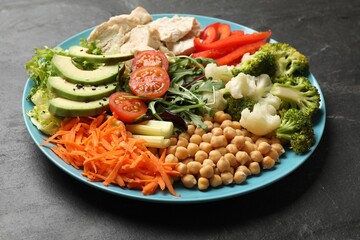 Balanced diet and healthy foods. Plate with different delicious products on black table