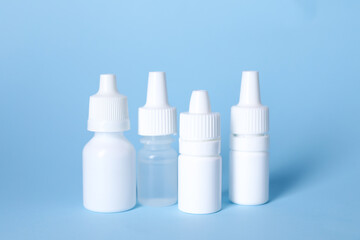 Obraz na płótnie Canvas Bottles of medical drops on light blue background
