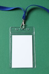 Blank badge with string on green background, top view