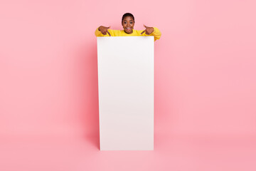 Full length photo of excited funny girl direct fingers empty space placard isolated on pink color background