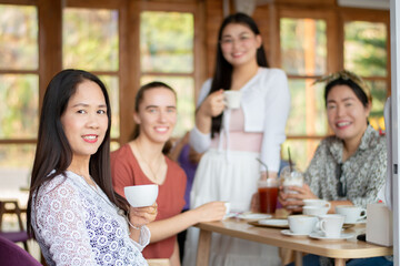 group of friends sitting in cafe and drinking coffee