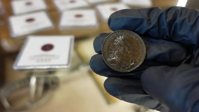 Collector examining Portuguese Copper coin from the Modern Age