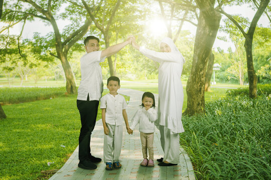 Happy Asian muslim family of four having fun together at park