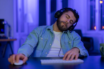 Man fell asleep while gaming on PC in neon-lit room - obrazy, fototapety, plakaty