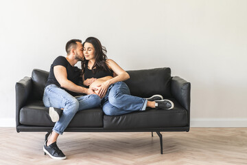 Pregnant woman sitting on the bed with husband
