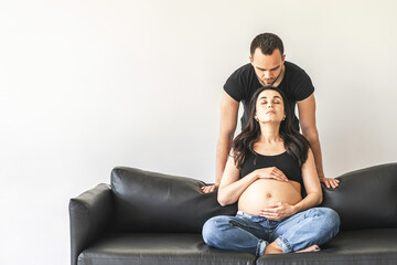 Pregnant woman sitting on couch with man