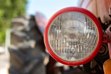 Close-up of the headlight of an old vintage tractor. Detail of the headlight of an old vintage tractor on a sunny day © Caneritir