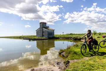 Woman cycles on an e-bike through the Po Delta in Northern Italy