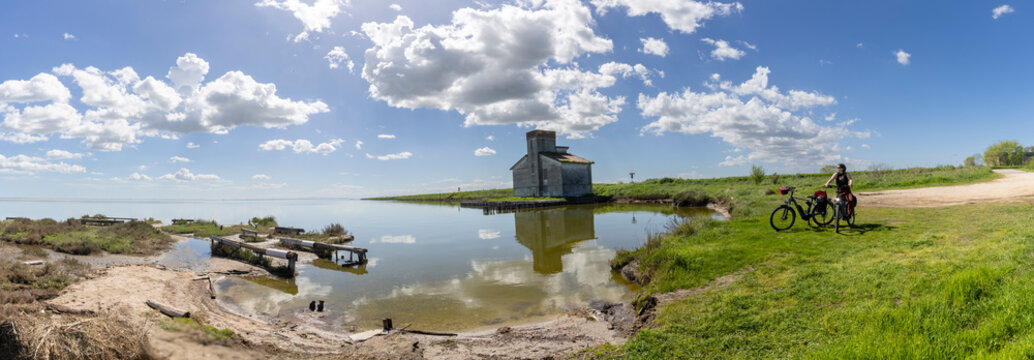 Woman cycles on an e-bike through the Po Delta in Northern Italy