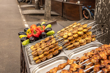 Street food stall. Roasted vegetables, vegetables and chicken grilled on skewers