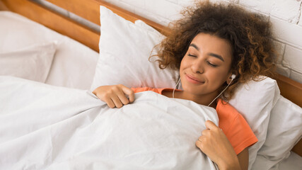 Relaxed woman listening calm music in earphones
