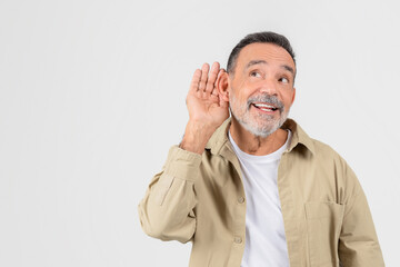 Senior man cupping ear listening carefully, copy space