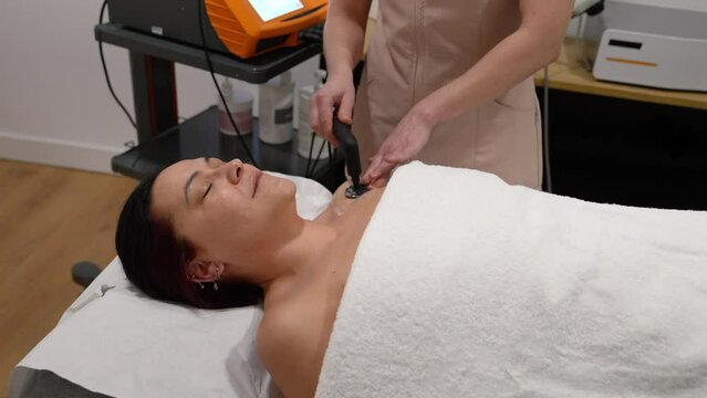 Patient relaxes during a soothing electrotherapy treatment on neck.