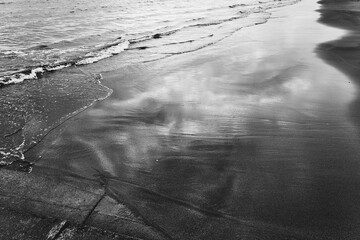 水が陸と出会う場所で、波は岸辺に新しい物語を刻みます。 - obrazy, fototapety, plakaty