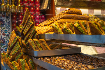 Close-up of the delicious Turkish sweet baklava with green pistachios and other Turkish sweets on the counter.