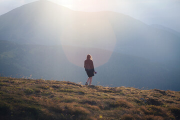 Young Girl in Black Outfit Walks in High Carpathian Mountains - obrazy, fototapety, plakaty