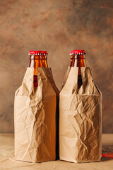 Two beer bottles are in brown paper bags