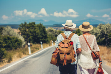 Adult couple walking along the road, hitchhiking - 780527511