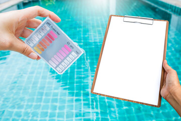 Girl hand holding swimming pool tester and blank report on wooden clipboard over blurred clear swimming pool water background, water quality testing and report, pool service and maintenance